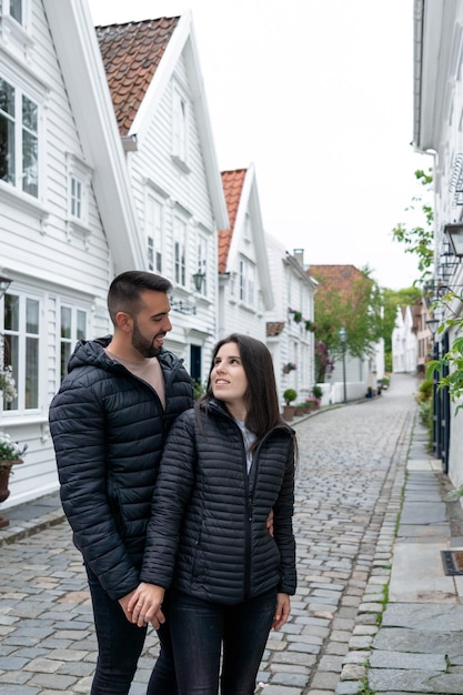 Young tourist couple in a street known for its typical Scandinavian white houses in Stavanger Norway