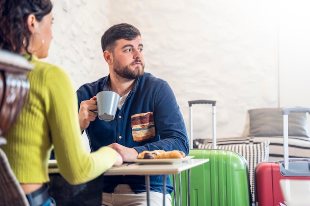 Young tourist couple talking and having breakfast in a hotel dining room