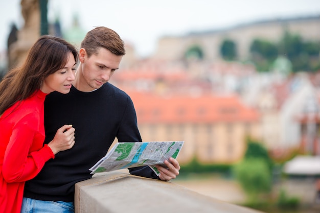 Photo young tourist couple traveling on holidays in europe smiling happy. caucasian family with city map in search of attractions