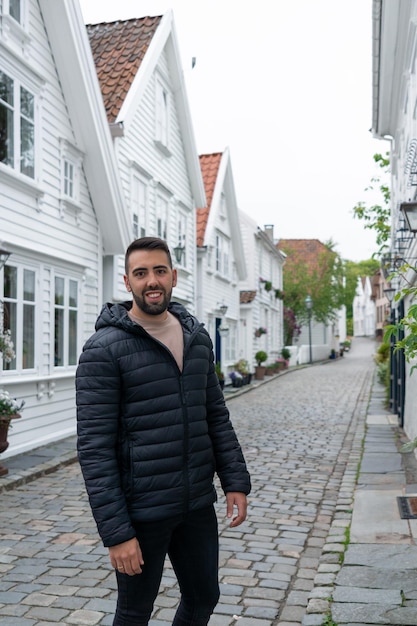 Young tourist in a street known for its typical Scandinavian white houses in Stavanger Norway