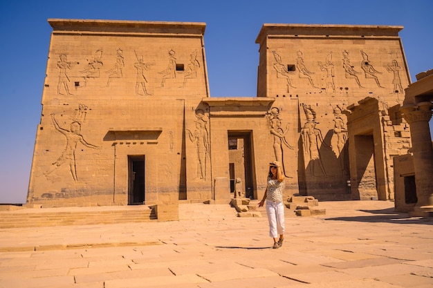 A young tourist visiting the Temple of Philae a GrecoRoman construction seen from the Nile River a temple dedicated to Isis goddess of love Aswan Egyptian