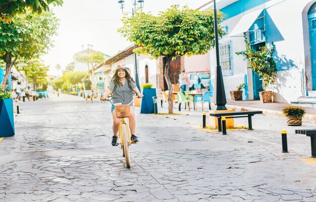 Young tourist woman riding a bicycle on the streets of Granada Nicaragua Happy tourist girl riding a bicycle on Calzada street