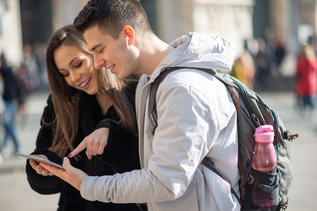 Young tourists couple using a digital tablet in a city