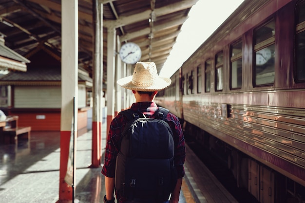 Photo young traveler man stand on railroad station