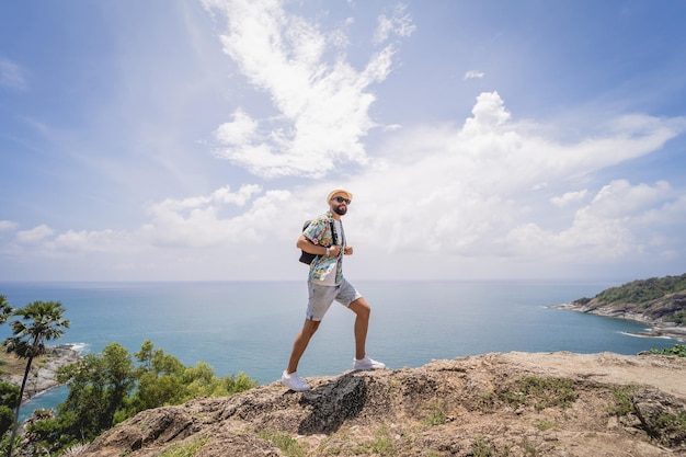 Young traveler man at summer holiday vacation with beautiful mountains and seascapes at background