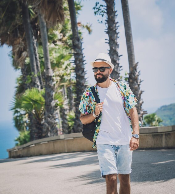 Photo young traveler man at summer holiday vacation with beautiful palms and seascapes at background