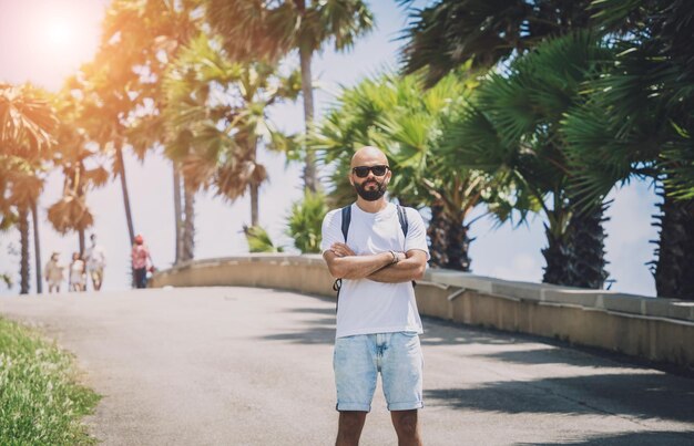 Photo young traveler man at summer holiday vacation with beautiful palms and seascapes at background