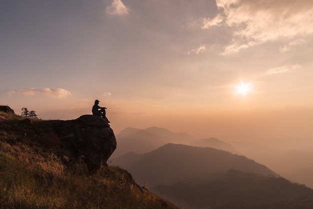 Young traveler relaxing and looking beautiful landscape on top of mountain, Adventure travel lifestyle concept