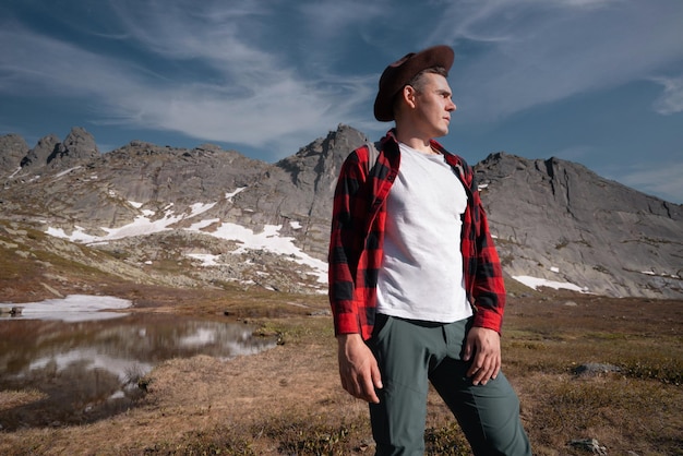 Young traveler tourist dressed as hipster with backpack walks in mountains