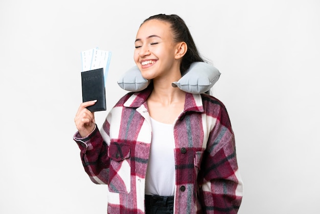 Young Traveler woman holding a passport over isolated white background laughing in lateral position