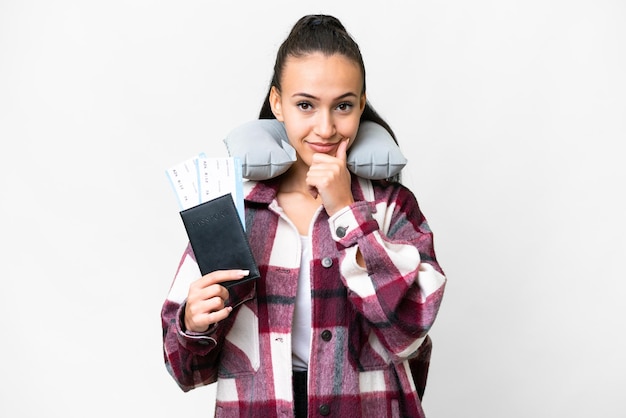 Young Traveler woman holding a passport over isolated white background thinking