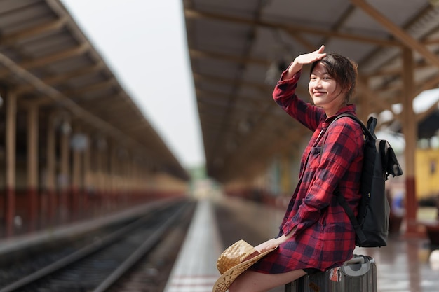 Young traveler woman planning trip at train station Summer and travel lifestyle concept