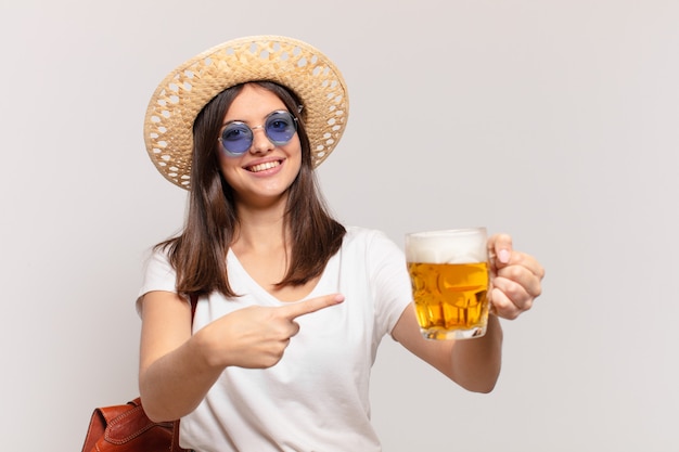 Young traveler woman pointing or showing and holding a beer