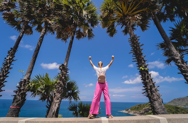 Young traveler woman at summer holiday vacation with beautiful palms and seascapes