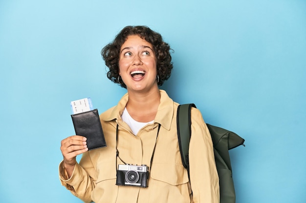 Young traveler woman with backpack and airplane ticket studio shot