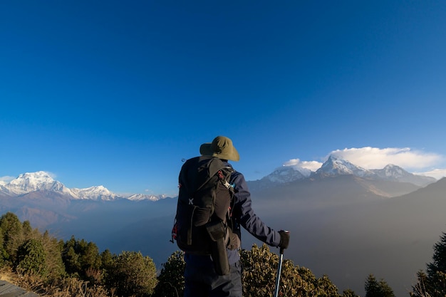 A young traveller trekking in Poon Hill view point in Ghorepani Nepalx9xA