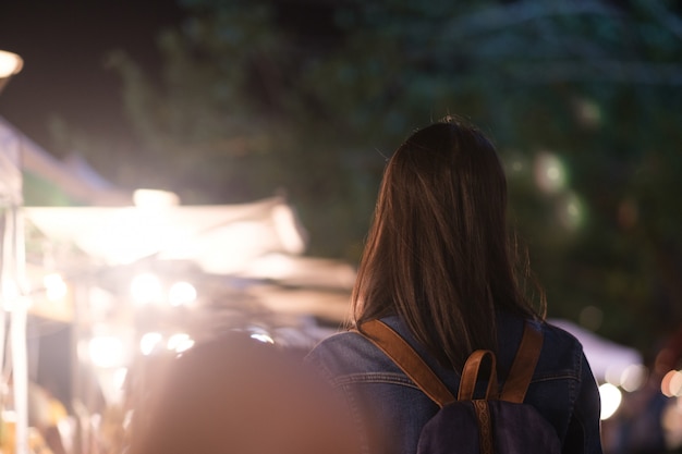 Young traveller woman walking on city street at night.