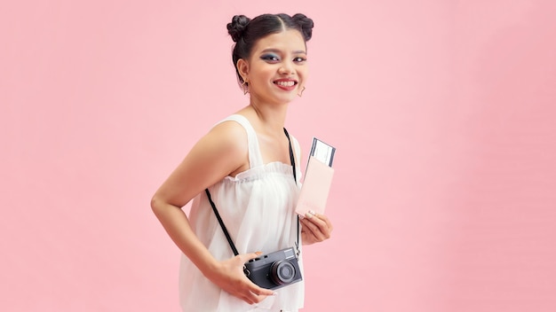 Young travelling girl isolated on pink