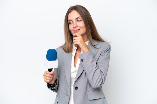 Young TV presenter caucasian woman isolated on white background looking to the side and smiling