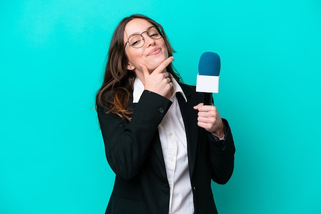 Young TV presenter woman isolated on blue background happy and smiling