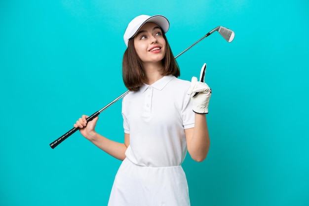 Young Ukrainian golfer player woman isolated on blue background pointing up a great idea