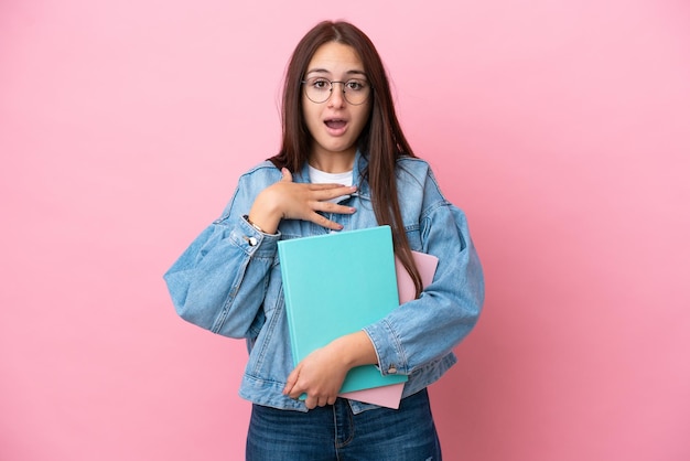 Young Ukrainian student woman isolated on pink background surprised and shocked while looking right