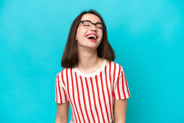 Young Ukrainian woman isolated on blue background laughing