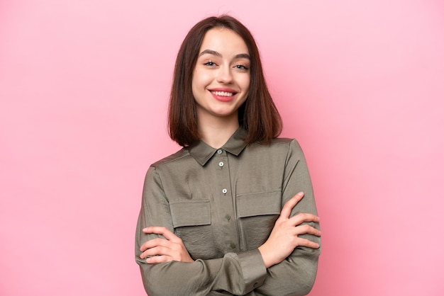 Young Ukrainian woman isolated on pink background keeping the arms crossed in frontal position