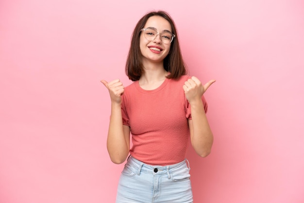 Young Ukrainian woman isolated on pink background with thumbs up gesture and smiling