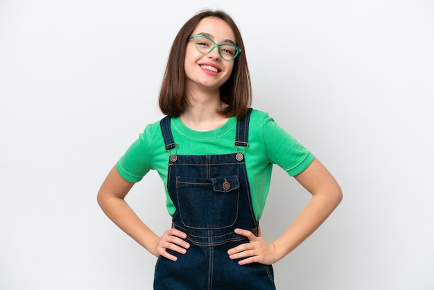 Young Ukrainian woman isolated on white background posing with arms at hip and smiling