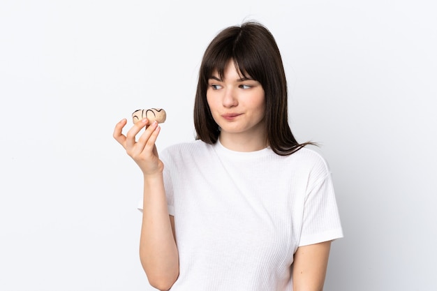 Young Ukrainian woman isolated on white wall holding a donut