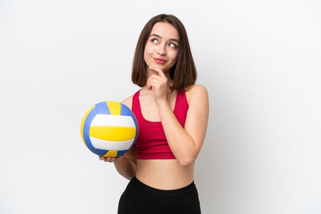 Young Ukrainian woman playing volleyball isolated on white background and looking up