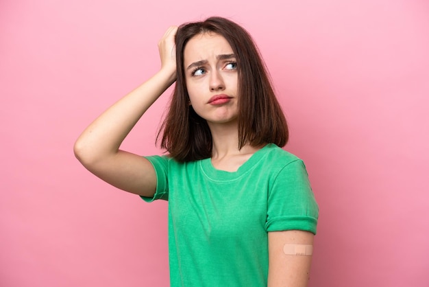 Young Ukrainian woman wearing a band aids having doubts and with confuse face expression