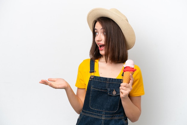 Young Ukrainian woman with a cornet ice cream isolated on white background with surprise facial expression