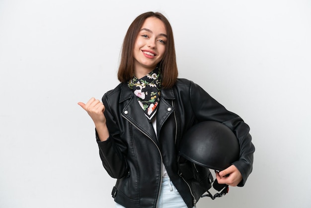 Young Ukrainian woman with a motorcycle helmet isolated on white background pointing to the side to present a product