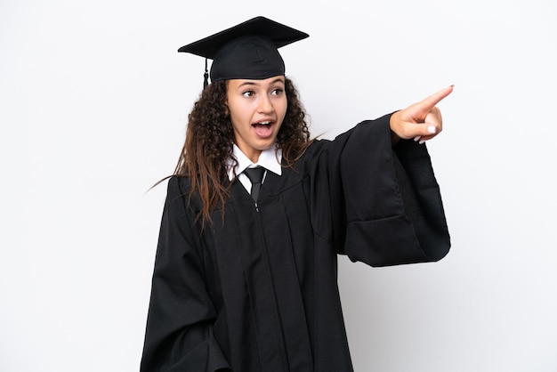 Young university graduate Arab woman isolated on white background pointing away