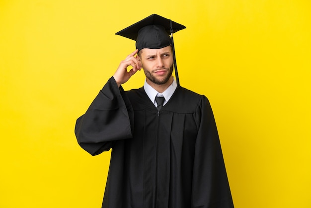 Young university graduate caucasian man isolated on yellow background having doubts and with confuse face expression