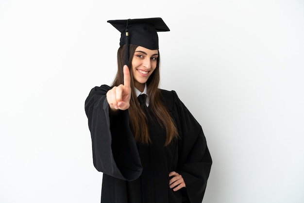 Young university graduate isolated on white background showing and lifting a finger