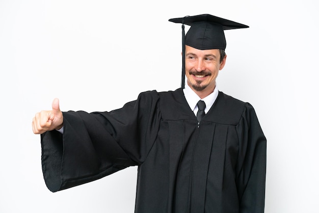 Young university graduate man isolated on white background giving a thumbs up gesture