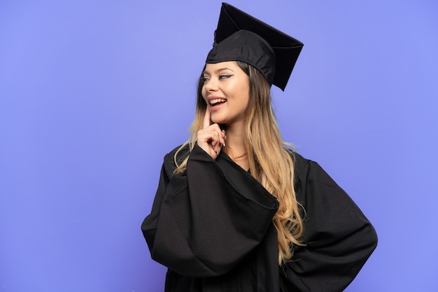 Young university graduate Russian girl isolated on white background thinking an idea while looking up