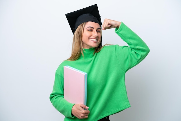 Young university graduate woman isolated on white background doing strong gesture