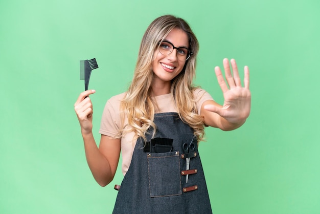 Young Uruguayan hairdresser woman over isolated background counting five with fingers