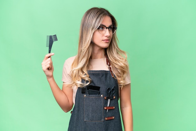 Young Uruguayan hairdresser woman over isolated background looking to the side