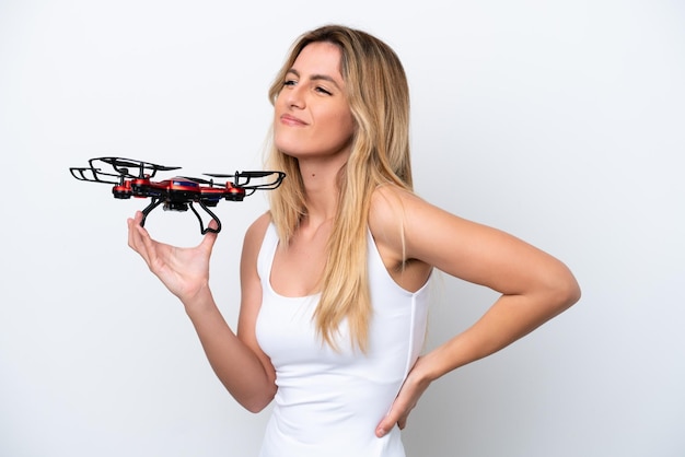 Young Uruguayan woman holding a drone isolated on white background suffering from backache for having made an effort