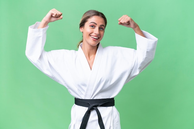 Young Uruguayan woman over isolated background doing karate and making strong gesture