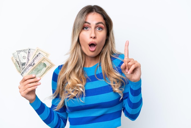 Young Uruguayan woman taking a lot of money isolated on white background intending to realizes the solution while lifting a finger up