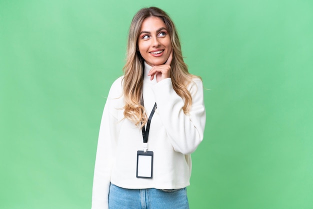 Young Uruguayan woman with ID card over isolated background thinking an idea while looking up