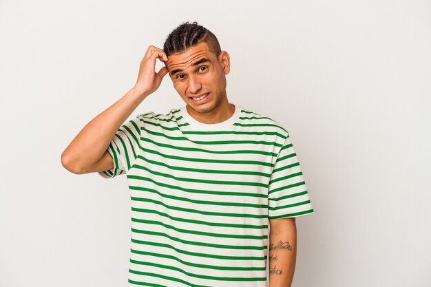 Young venezuelan man isolated on white background forgetting something, slapping forehead with palm and closing eyes.