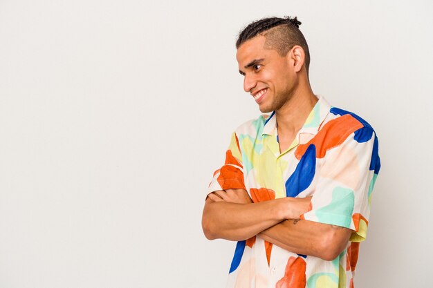 Young venezuelan man isolated on white background smiling confident with crossed arms.