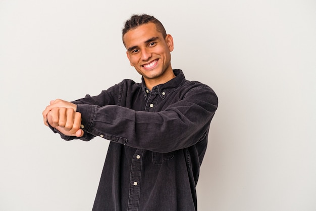 Young venezuelan man isolated on white background stretching arms, relaxed position.